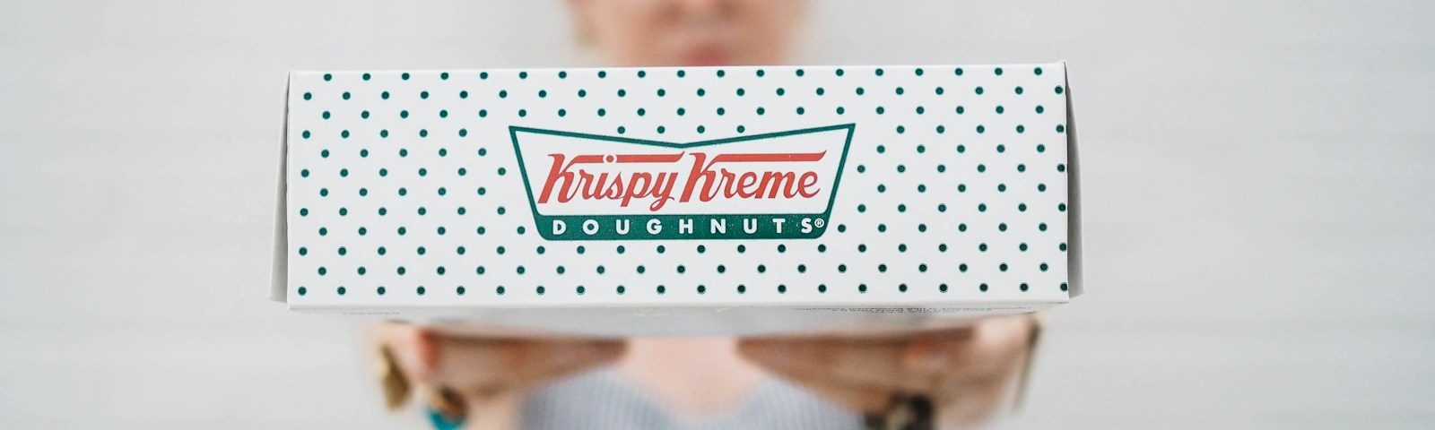 woman showing Krispy Kreme box