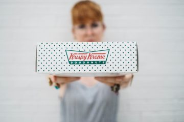 woman showing Krispy Kreme box